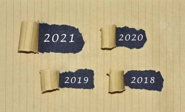 2021, 2020, 2019 ve 2018 numaralı sayılar yırtık kahverengi kağıda yazılmış. Yeni yıl kavramı