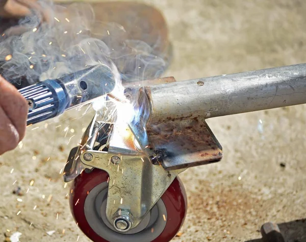 Worker Welding Machine Fixing Caster Wheels Fiery Sparks Flying — Foto Stock