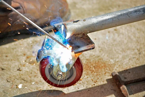 Worker Welding Machine Fixing Caster Wheels Fiery Sparks Flying — Stock Photo, Image