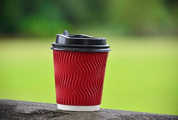 Egy Piros Színű Csésze Kávé Elvinni Tetején Nagy Elmosódott Zöld — Stock Fotó