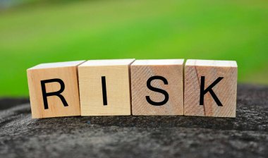 Tahta küp bloktaki risk metni büyük taşın üstünde bulanık yeşil arkaplanlı