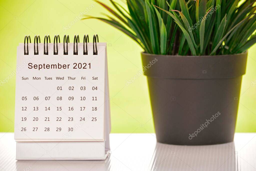 White September 2021 calendar with green backgrounds and potted plant