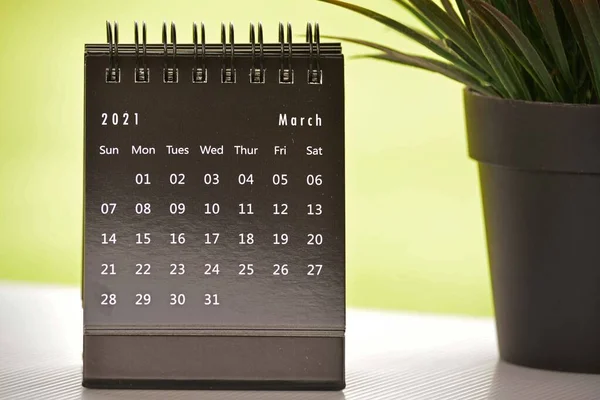 Черный март 2021 календарь с зеленым фоном и горшком растения. Концепция 2021 — стоковое фото