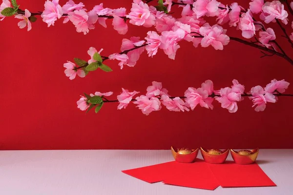 中国の旧正月の祭りは 赤の背景に赤いパケットと金のインゴットを飾る — ストック写真