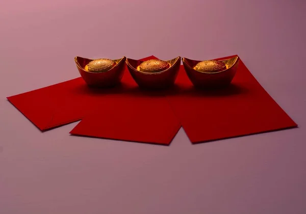 中国の旧正月春祭りの装飾はピンクの背景に力や赤のパケットと金のインゴットや黄金の塊 — ストック写真