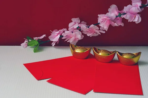 中国の旧正月春祭りの装飾は幸運 金の流れの梅の花と赤い背景にパケットや金のインゴットや黄金の塊を力や赤 — ストック写真