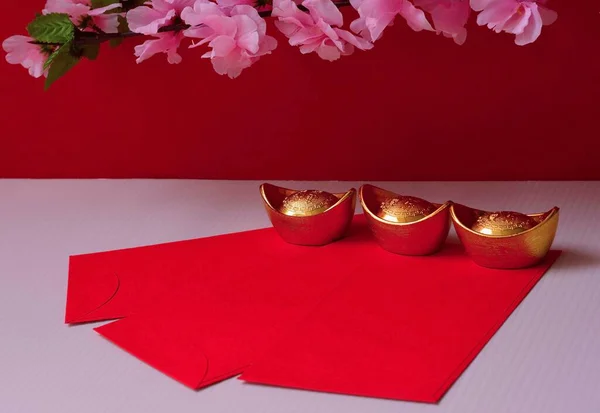 中国の旧正月春祭りの装飾は幸運 金の流れの梅の花と赤い背景にパケットや金のインゴットや黄金の塊を力や赤 — ストック写真