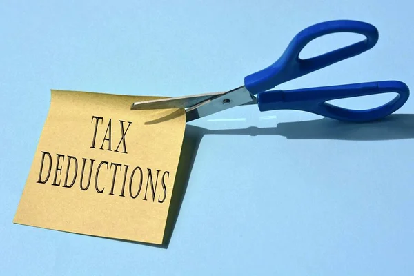 Nůžky Které Stříhají Žlutý Notepad Daňovými Odpočty Text Modrém Pozadí — Stock fotografie