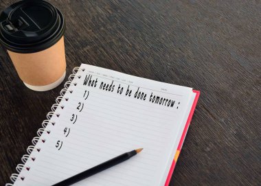 Not defterinde bir fincan kahve ve bir kalem arkaplanı olan metin