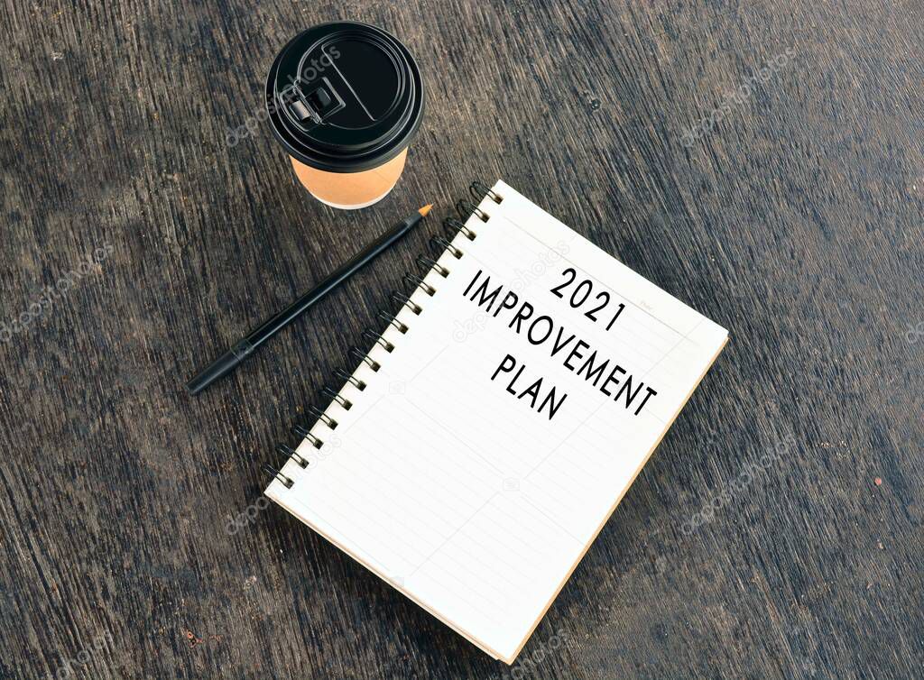 Text on notepad with disposable coffee cup wooden table
