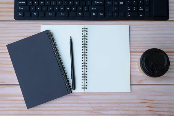 Kantoorruimte met toetsenbord, notitieboekjes, pen en koffie. Ruimte voor tekst — Stockfoto