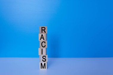 Ahşap blokta mavi arka planda ırkçılık metni