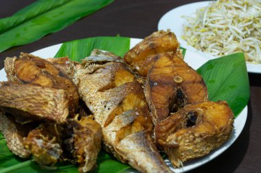 Yeşil yapraklı kızarmış balık.