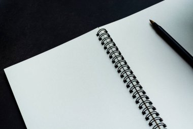 Siyah arka planı olan beyaz bir defter. Metin ve üst görünüm için boşluk