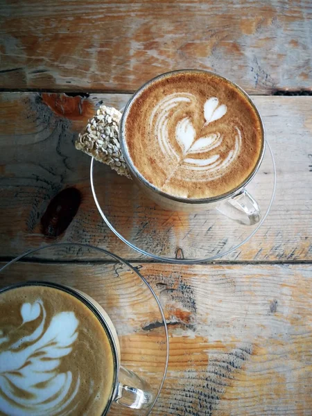 Coffee in glass cup with cookies on wooden table in cafe — Stock Fotó