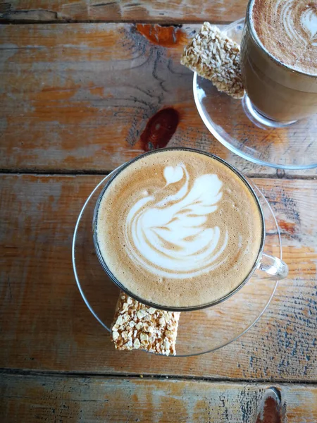 Coffee in glass cup with cookies on wooden table in cafe — Stock Fotó