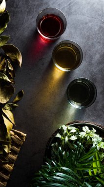 Kırmızı, sarı ve yeşil sıvılar ve buzlarla dolu üç bardak.