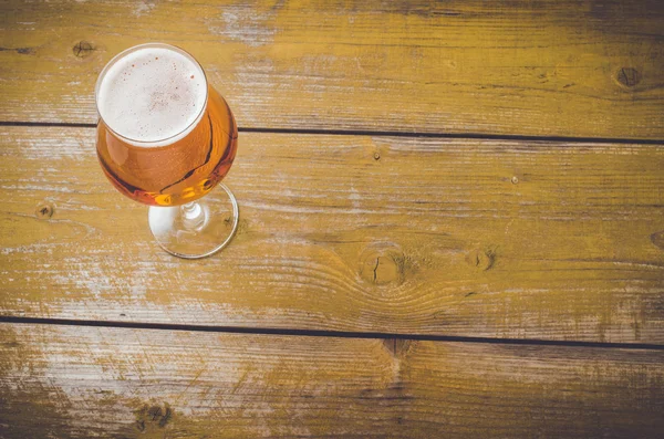 Beer glass on an old wooden table. Close up — Stock Photo, Image