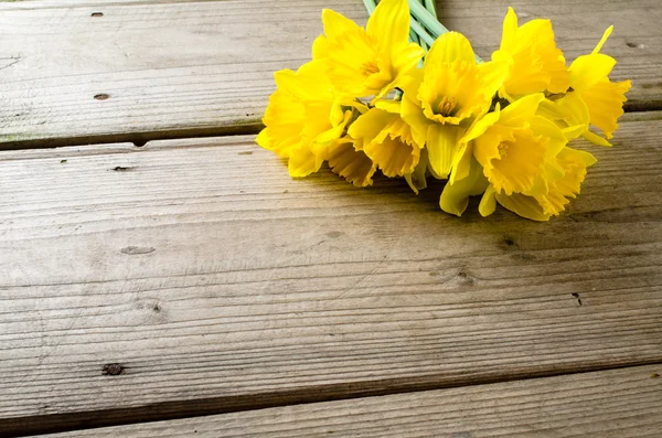 Narcisos amarelos na mesa de madeira — Fotografia de Stock