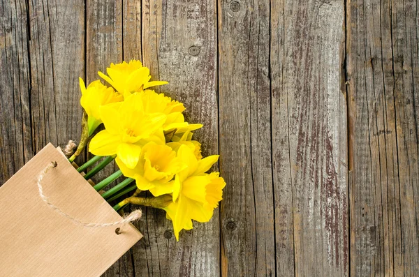 Narcisos amarelos na mesa de madeira — Fotografia de Stock