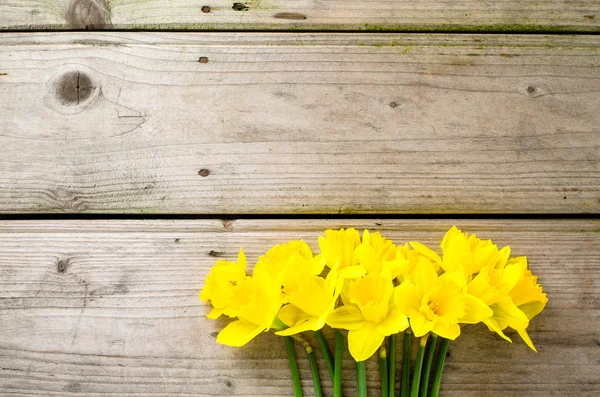 Yellow daffodils on wooden table — Stock Photo, Image