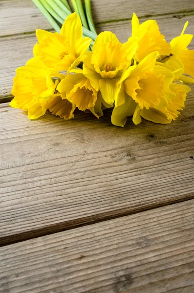 Narcisos amarelos na mesa de madeira — Fotografia de Stock