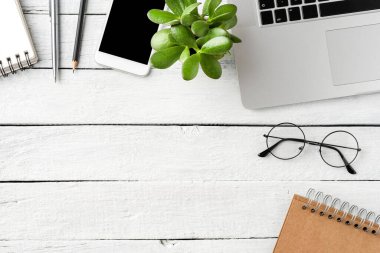 Ofis masaüstü dizüstü bilgisayar ve iş aksesuarları ile ahşap arka planda kopyalanmış