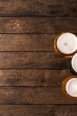 Kopyalama alanı olan ahşap masada bira bardakları.