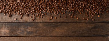 Telif alanı olan ahşap arka planda kahve çekirdekleri.