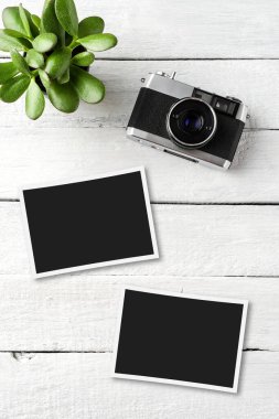 Beyaz ahşap masada fotoğraf makinesi olan boş çerçeveler. Üst görünüm