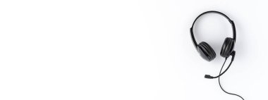 Çağrı merkezi konsepti. Kopyalama alanı olan beyaz masaüstündeki yardım masası kulaklığı. Pankart