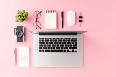Bilgisayarlı modern çalışma alanı kavramı ve pembe arka plandaki iş aksesuarları. Ofis masaüstü. Üst görünüm 