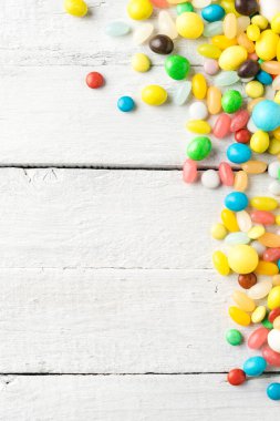  Telif alanı olan beyaz ahşap masadaki renkli tatlılar. Üst görünüm