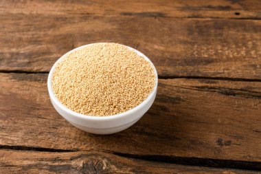 Antika ahşap arka planda kasede Amaranth tohumları