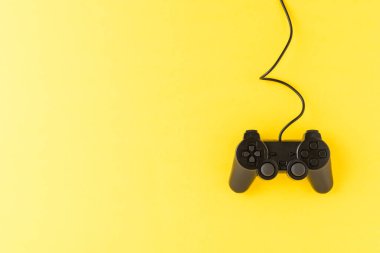 Telif uzayı ile sarı arkaplanda video oyunu denetleyici. Bilgisayar oyuncusu konsepti. Üst görünüm
