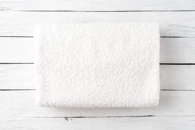 Beyaz ahşap arka planda temiz bir spa havlusu. Kapat.