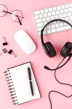 Yardım masası kulaklığı ve pembe arka planda aksesuarlar. Çağrı merkezi kavramı