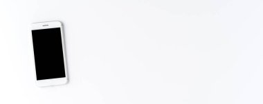 Beyaz masaüstünde boş ekranı olan akıllı telefon. Pankart