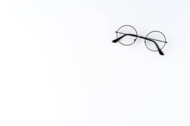 Telif alanı olan yuvarlak gözlükleri beyaz masanın üzerine koy.