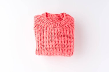 Pembe katlanmış süveter beyaz arka planda izole edilmiş. Düz yatıyordu. Üst görünüm