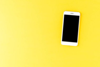 Sarı arka plandaki akıllı telefon. Üst görünüm