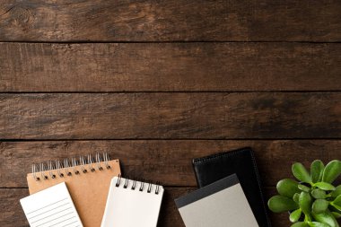 Geçmişe dönük iş geçmişi ve ahşap masadaki defterler. Ofis masaüstü