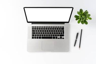 Boş ekranlı dizüstü bilgisayar ve beyaz arka planda izole edilmiş iş aksesuarları. Ofis masaüstü. Üst görünüm