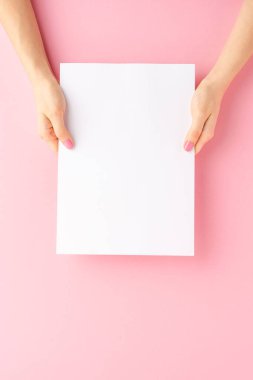 Pembe arka planda boş kağıt kağıtlar gösteren kadın elleri. Kapat. 