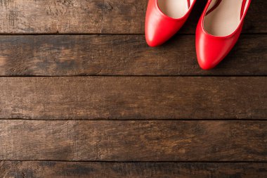 Tahta arka planda kırmızı topuklu ve kopyalanmış. Üst görünüm