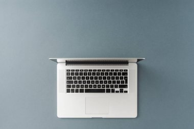 Gri arka planda, telif uzayı olan bir dizüstü bilgisayar görüntüsü. Ofis masaüstü. Düz yatıyordu