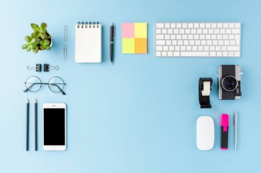 Modern çalışma alanı konseptinin mavi arka plandaki iş aksesuarlarıyla telif alanı ile genel görüntüsü. Ofis masaüstü. Düz yatıyordu