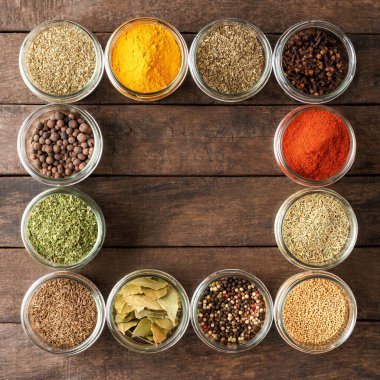 Kâselerdeki çeşitli çeşitler. Kopyalama alanı ile ahşap arkaplan üzerindeki baharat koleksiyonu
