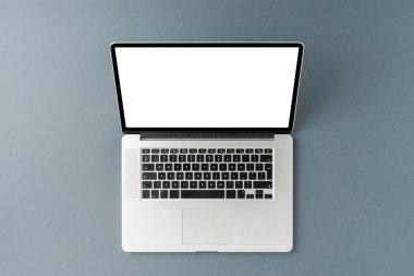 Gri arkaplanda boş ekran olan dizüstü bilgisayar. Ofis masaüstü. Üst görünüm
