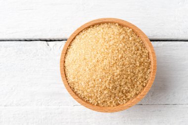 Kırsal ahşap masada kasede kahverengi kamış şekeri. Üst görünüm